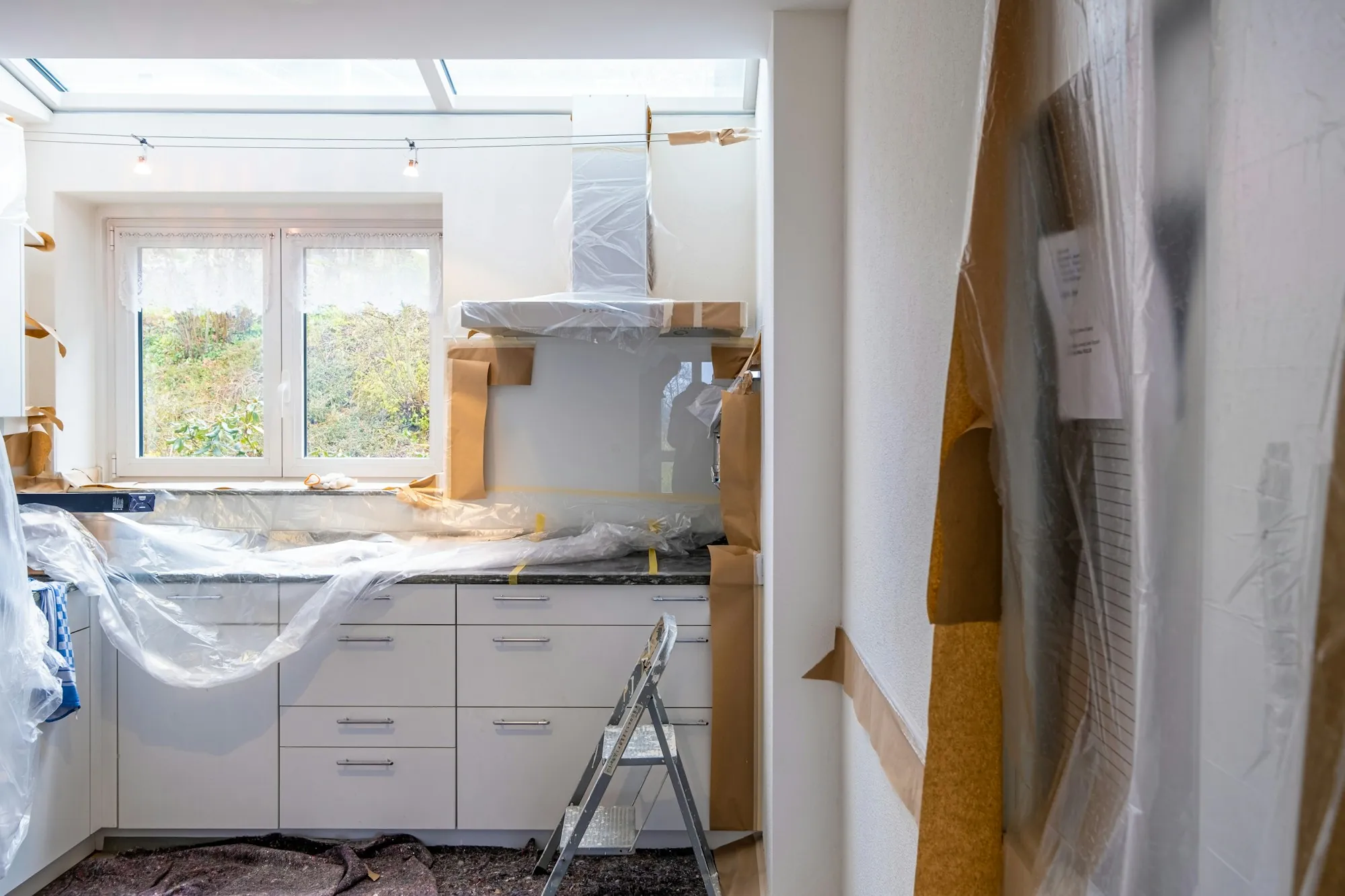 A kitchen mid-renovation with protective sheeting